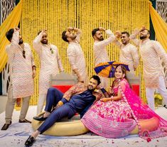 a group of men and women posing for a photo in front of a yellow backdrop