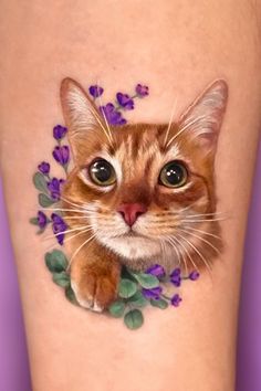 a close up of a cat with flowers on it's leg and the face of a cat