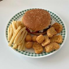 a hamburger and french fries are on a plate with a checkered tablecloth,