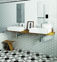 two sinks in a bathroom with black and white tiles on the floor, along with mirrors