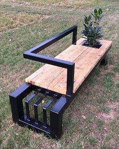 a wooden bench sitting on top of a grass covered field next to a small tree