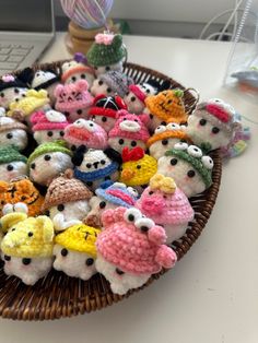 a basket filled with small stuffed animals on top of a white table next to a keyboard