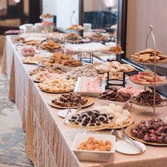 a buffet table filled with lots of pastries and desserts