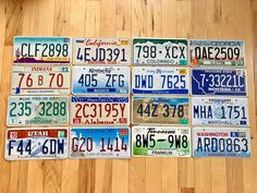 several different license plates laid out on a wooden floor in front of a wood floor