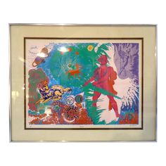 an abstract painting with various colors and shapes in a white frame on a wall or floor