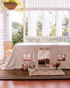 a doll house is set up on the porch