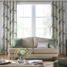 a living room filled with furniture and a window covered in green curtained drapes