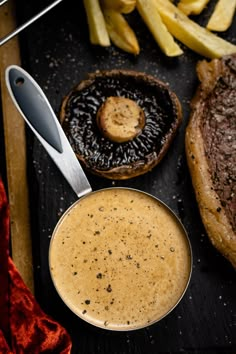 a steak, fries and sauce on a table