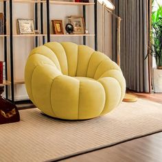 a yellow chair sitting on top of a wooden floor next to a book shelf filled with books