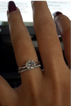 a woman's hand with a diamond ring on it