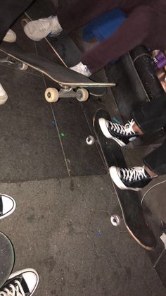 several skateboarders are standing around with their feet on the ground and one is holding his board