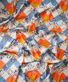 an orange, blue and white patchwork quilt