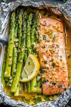 salmon and asparagus in foil with lemon wedges