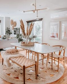 a dining room table and chairs in front of a large window with lots of natural light