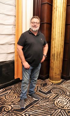 a man standing in front of two tall gold pillars