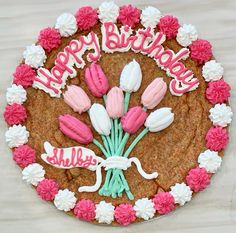 a birthday cake decorated with pink and white flowers