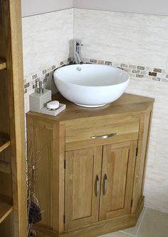 a bathroom sink sitting on top of a wooden cabinet