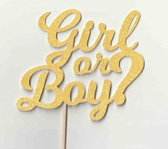 a cake topper with the words girl or boy written in gold glitter on it