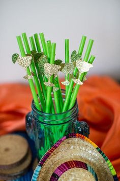 green straws in a mason jar with paper butterflies on them and some other items