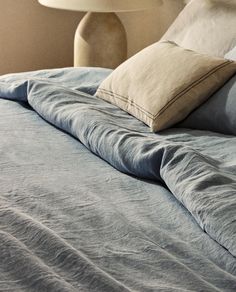 a bed with blue sheets and pillows on it