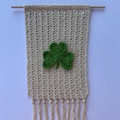 a crocheted wall hanging with a four leaf clover on it's side