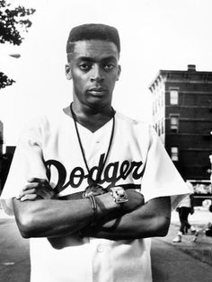 a black and white photo of a baseball player with his arms crossed in front of him