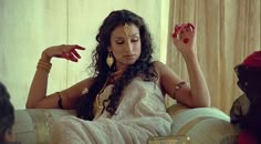 a woman sitting on top of a couch in a white dress