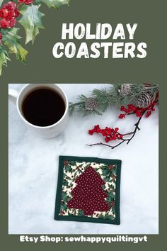 the holiday coaster is next to a cup of coffee and holly wreath with red berries