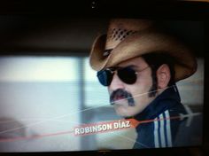 a television screen with a man wearing a cowboy hat and sunglasses on it's face