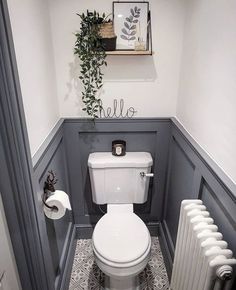 a white toilet sitting in a bathroom next to a radiator and towel rack