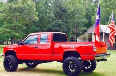 a red pick up truck with an american flag on the back