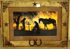 a wooden frame with a painting of two horses and a man holding a cross on it