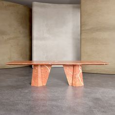 a long table sitting on top of a cement floor next to a tall white wall