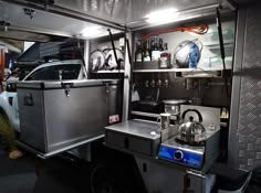 the inside of a vehicle with stainless steel appliances and cooking utensils on it