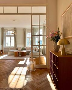 an open living room with wooden floors and large windows