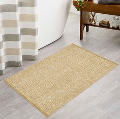 a bathroom with a bathtub and rug on the floor