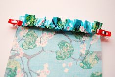 a close up of a piece of fabric with flowers on it and two red handles