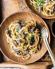 two plates of pasta with mushrooms and parsley