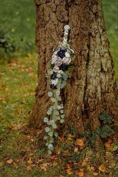 a wedding bouquet hanging from the side of a tree