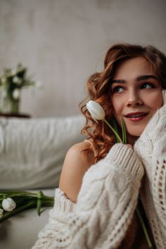 a woman with flowers in her hair and sweater