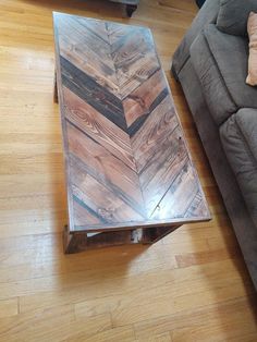 a wooden coffee table sitting on top of a hard wood floor next to a couch