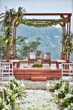 an outdoor wedding setup with chairs and greenery