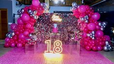 the entrance to an event decorated with pink and silver balloons