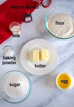 ingredients to make an egg cake laid out on a marble counter top, including flour, butter, sugar and eggs