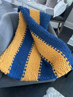 a blue and yellow blanket sitting on top of a couch