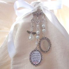 a white bag with some pearls on it and a necklace hanging from the front pocket