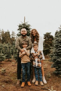 a family standing in front of christmas trees