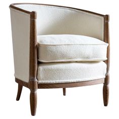 an upholstered chair with white fabric and wood legs