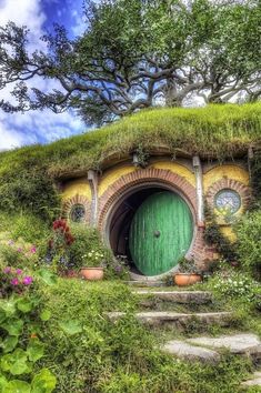 a hobbot house with green door and steps leading up to it