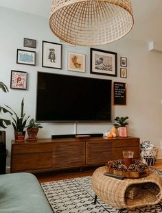 a living room filled with furniture and a flat screen tv mounted to the side of a wall